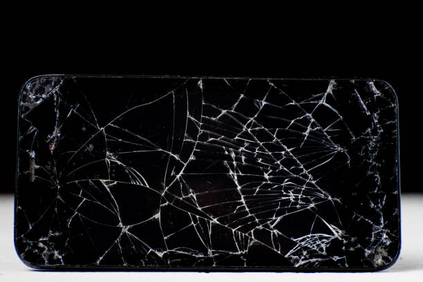 istock Broken mobile phone on a black and white background. Many cracks on the black touchscreen of the phone. Repair, screen replacement concept. 1368434146