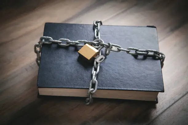 Photo of Book with chain and padlock. Information security