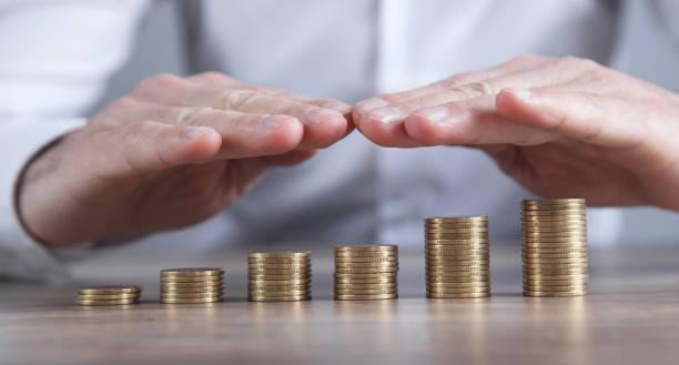 istock Male hands protect coins. Saving money 1368435026