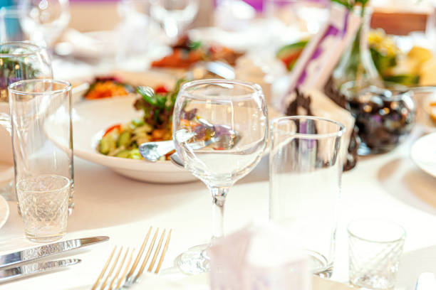 istock Fancy table set for dinner with napkin glasses in restaurant, luxury interior background. Wedding elegant banquet decoration and items for food arranged by catering service on white tablecloth table 1368435113