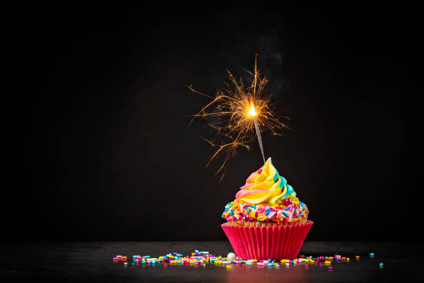 bunter geburtstag cupcake mit wunderkerze - back lit fotos stock-fotos und bilder