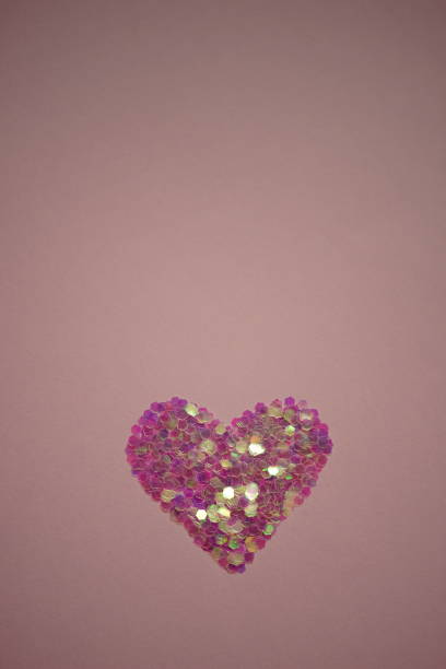 istock Pink heart made of sequins on a pale deep rose table. Copy space. 1368439282