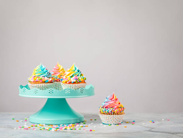 istock Pastel colored Rainbow Birthday Cupcakes on a stand 1368439303