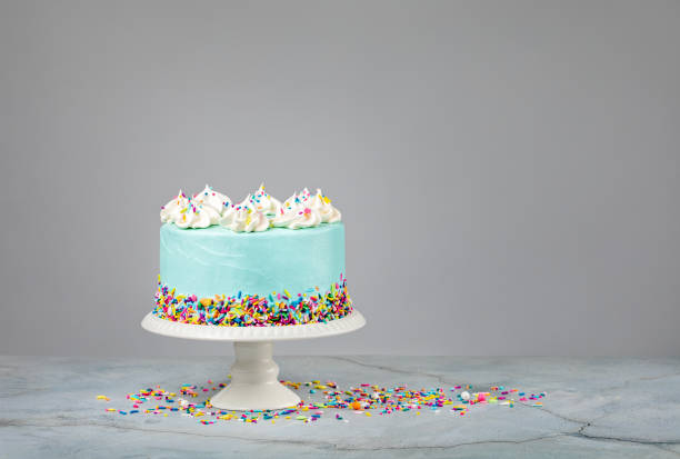 Blue Birthday Cake with Sprinkles over grey Blue Birthday Cake with colourful sprinkles over a light grey background. birthday cake green stock pictures, royalty-free photos & images