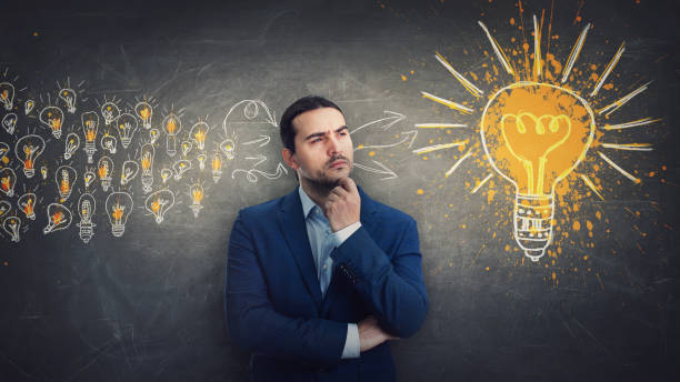 istock Ingenious businessman gathering ideas as joining all the lightbulbs into one big and bright bulb. Genius creativity and positive thinking concept 1368440110