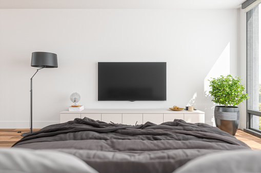 Modern bedroom with television and furniture.