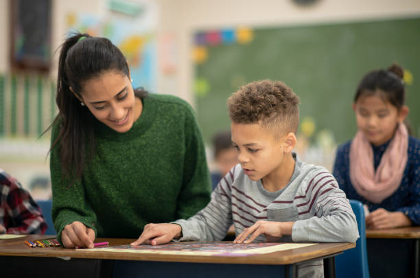 lehrer hilft einem schüler mit geographie - filipino ethnicity fotos stock-fotos und bilder