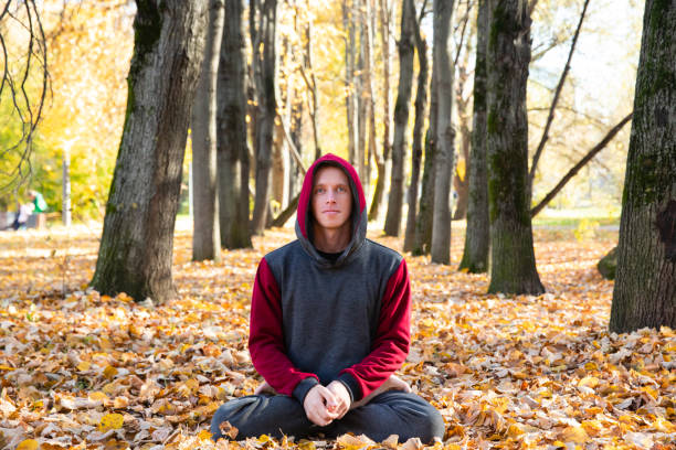 istock Sporty man practicing yoga in autumn park 1368451021
