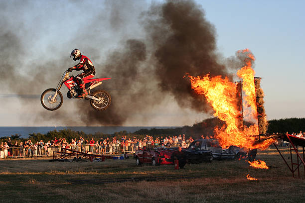 Bike Jumping Through Fire Motorbike jumping through wall of fire. skill, stunt, daredevil. Ring Of Fire stock pictures, royalty-free photos & images
