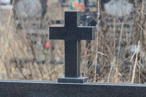 istock one black granite cross on a monument on a grave 1368454561