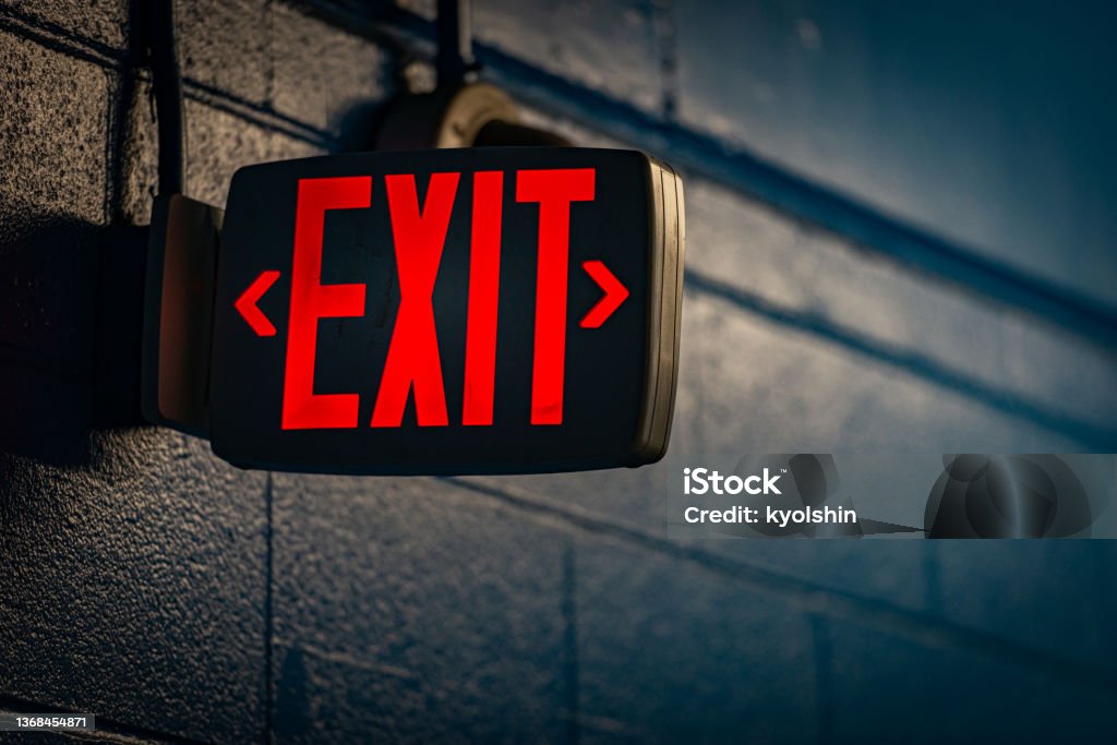 glowing exit sign by night on wall glowing exit sign by night on black wall Exit Sign Stock Photo