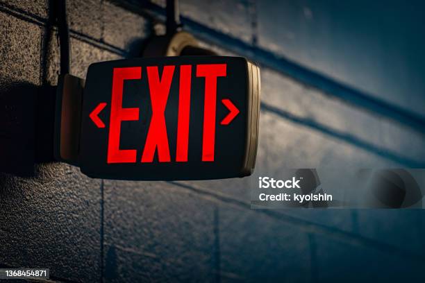 Glowing Exit Sign By Night On Wall Stock Photo - Download Image Now - Exit Sign, Leaving, USA