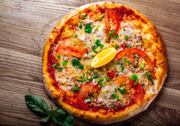 delicious pizza with tuna fish and lemon on wooden background - pizza tuna prepared fish cheese imagens e fotografias de stock