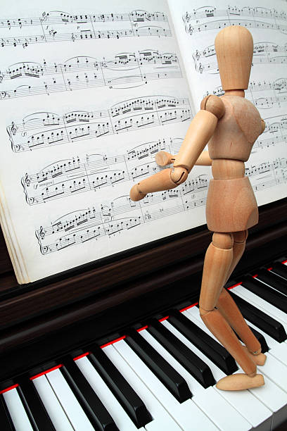 istock Wooden mannequin on piano keyboard 136845667