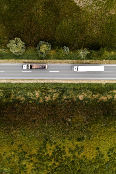istock Two large transporter semi-trucks on the road, aerial view 1368457291