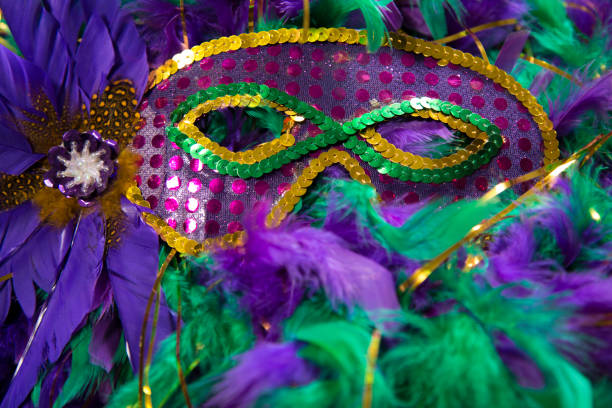 istock LV Mardi Gras sequined mask, decorated with feathers on a bed of feather Mardi Gras feather Boas. 1368457399
