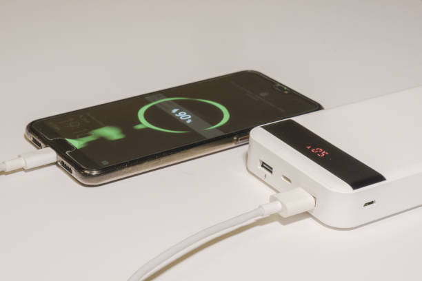 istock smartphone is charging from a power bank on a white background. 1368457470