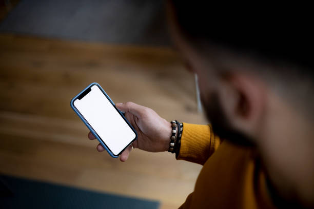 istock Rear high angle view of an unrecognizable Caucasian man using a smart phone at home 1368459836