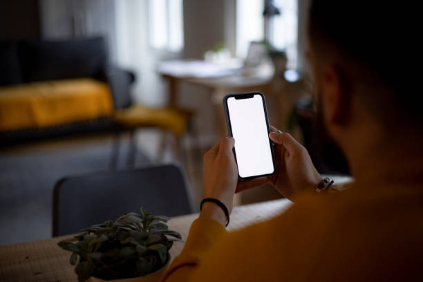 istock Rear high angle view of an unrecognizable Caucasian man using a smart phone at home 1368459837