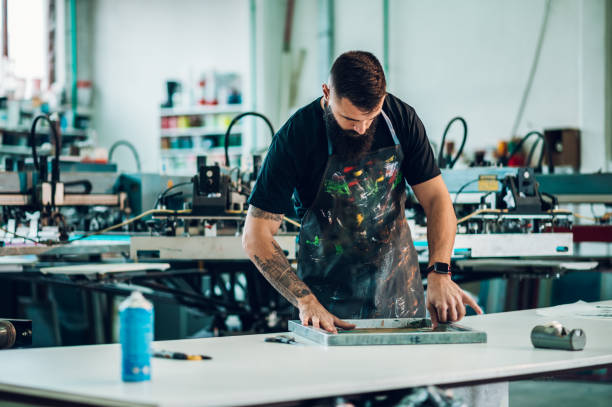 istock Male worker preparing screen printing film in a workshop 1368463825