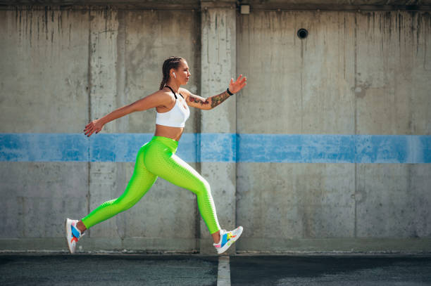 istock Attractive young woman running while training outside 1368464279