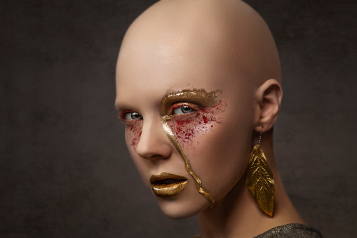 A bald cap on the model allowed the makeup to get the attention