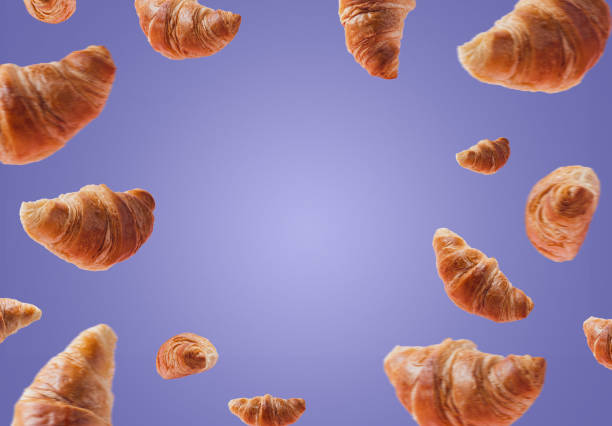 istock Croissants levitating or flying isolated on very pery purple background 1368467030