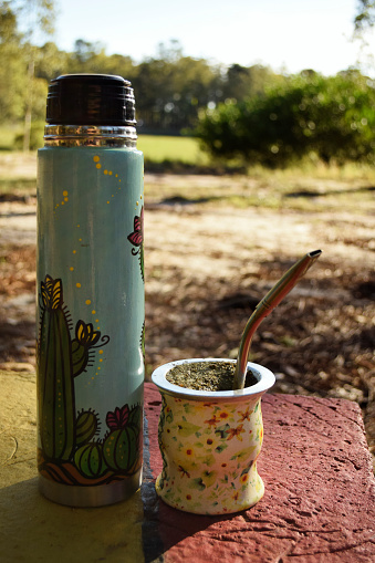 Uruguayan and colorful thermos and mate above a park bench