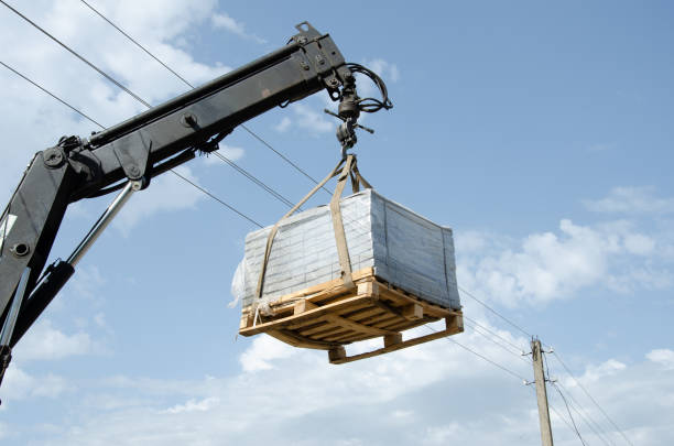 istock Unloading paving slabs from a truck. Men unload paving slabs using a manipulator. Workers unload building materials from a large machine. 1368469052