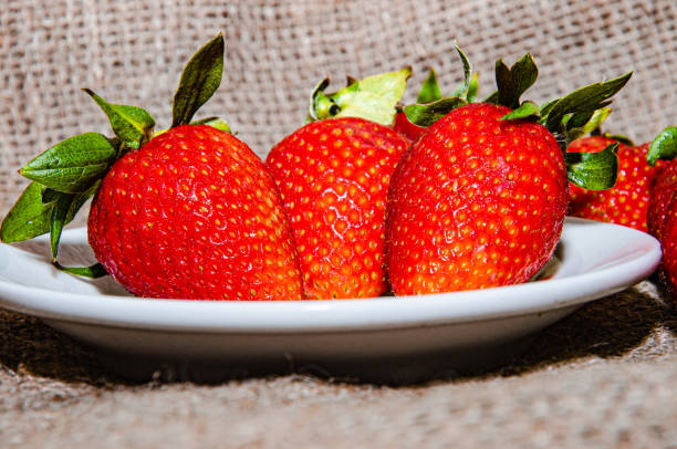 Fresh strawberries in a bowl on a textile background