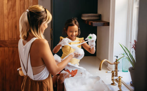 istock Young mother and daughter having fun with soap bubbles 1368471969