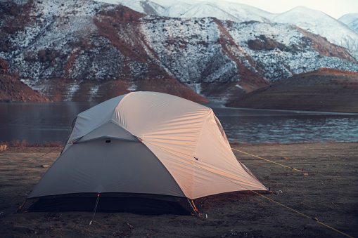 Camping in the mountains. Winter landscape, tent on the beach.