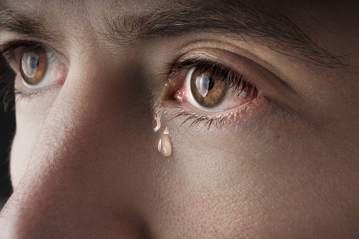 Primer plano de los ojos de un joven llorando con lágrimas photo