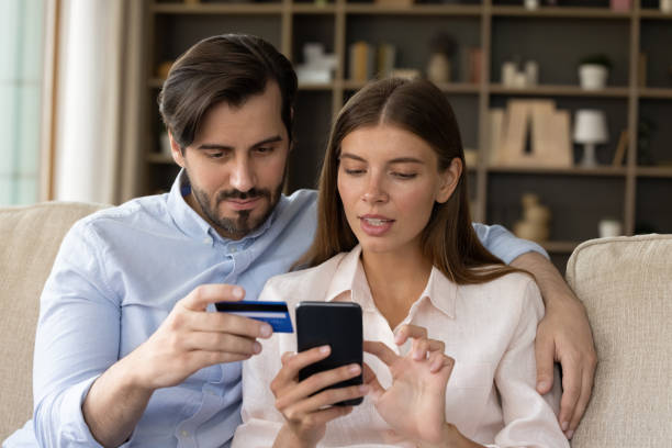 istock Focused millennial couple of consumers using banking app 1368476958