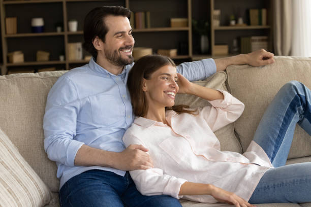 istock Happy young couple relaxing at home, enjoying leisure on sofa 1368476960