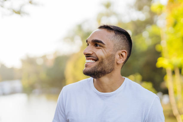 giovane atleta sorridente nel parco pubblico - adult muscular build athlete beautiful foto e immagini stock