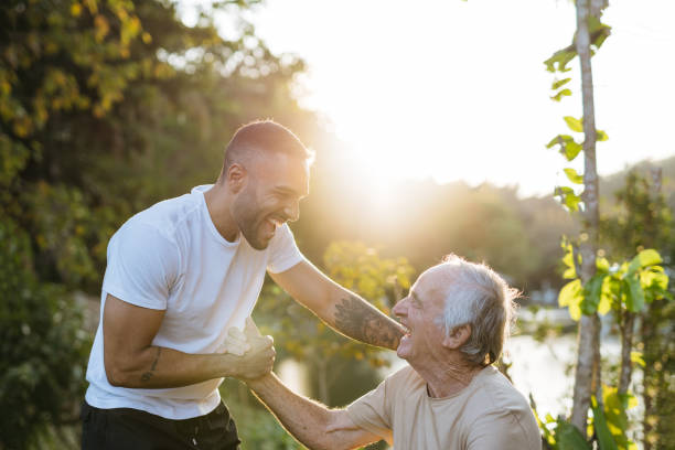 Young and old athlete greet each other in the natural park stock photo