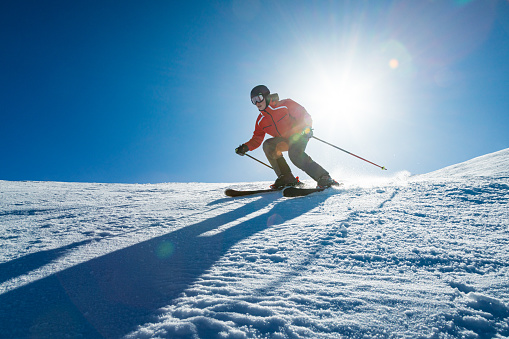 Young skier downhill skiing at Jahorina ski resort, Bosnia and Herzegovina, in winter afternoon.