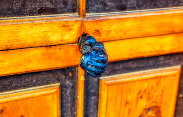 Classical decorative door handle in a shape of a hand on entrance door.