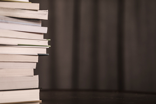 Dark stack of books. No people. Backgrounds. Desaturated for a dark, depression concept.