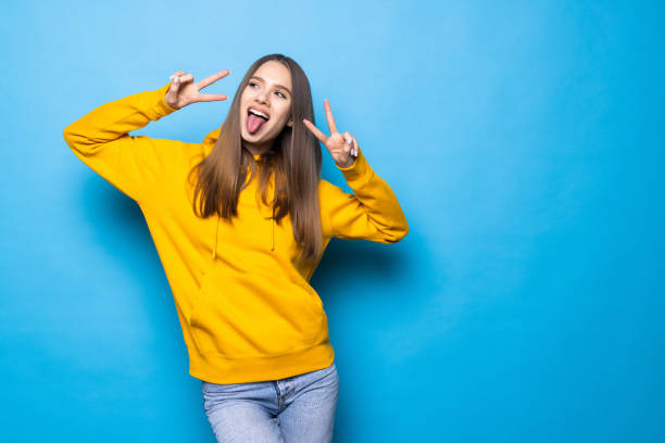 istock Young woman standing isolated over blue background showing peace gesture. 1368480690