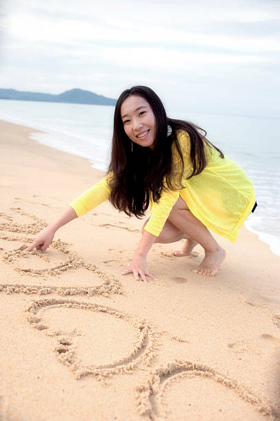 istock Asian beautiful girl writing word on the beach 136848234