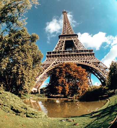 famous Eiffel Tower landmark and Paris roofs with clouds and sunshine, Paris France