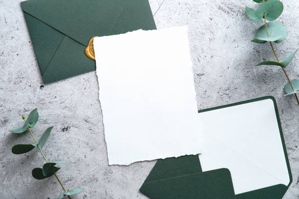 istock Wedding invitation card mockup with green envelopes and eucalyptus branches on stone table. Top view, flat lay, overhead. 1368485029