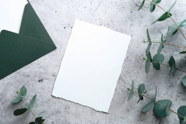 istock Blank paper card mockup and eucalyptus branches on rough stone surface top view. Wedding invitation card design, RSVP template. 1368485030