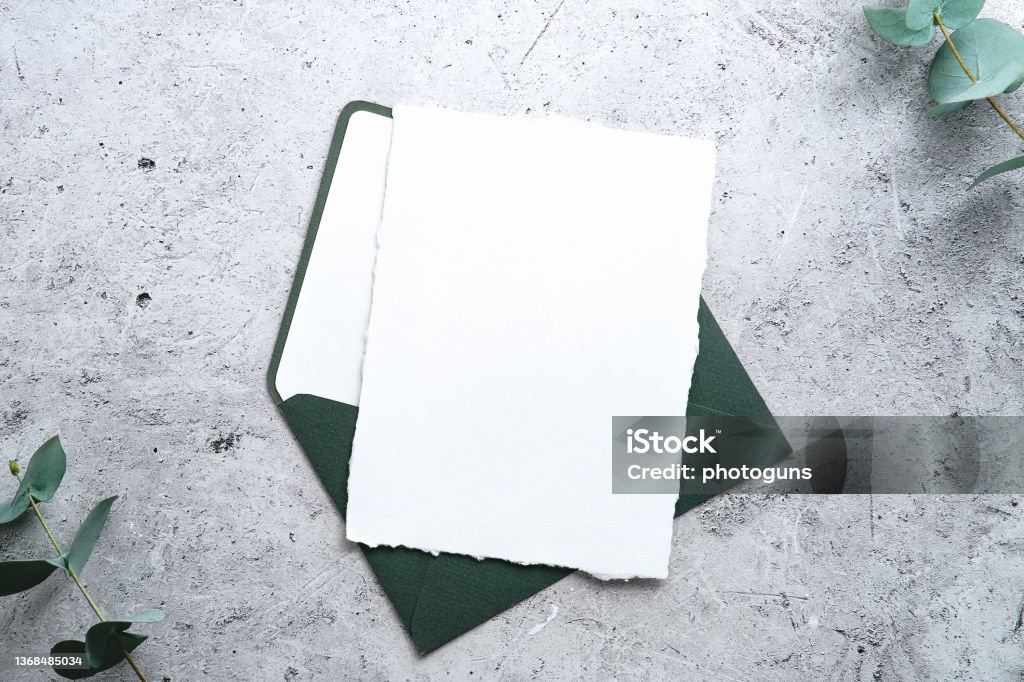 RSVP, wedding invitation mockup. Blank paper card with green envelope and eucalyptus on stone table top view. Letter - Document Stock Photo