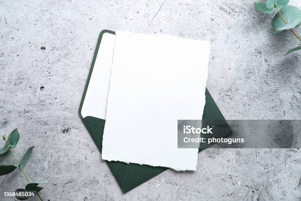 Rsvp Wedding Invitation Mockup Blank Paper Card With Green Envelope And Eucalyptus On Stone Table Top View Stock Photo - Download Image Now