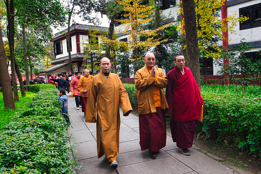 Chengdu, China - November 29 2009 : a group of monks is walking outside on the temple complex after a ceremony