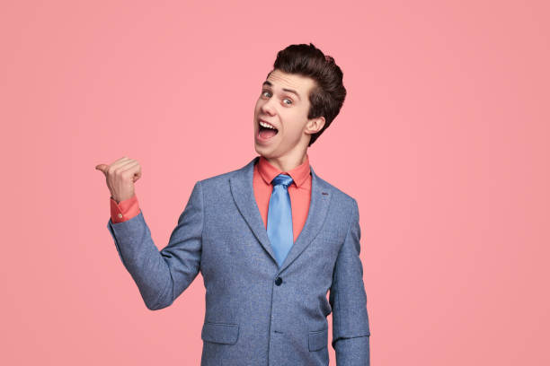 istock Happy man in suit pointing away 1368491524