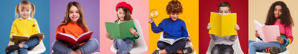 Happy pupils reading colorful books stock photo